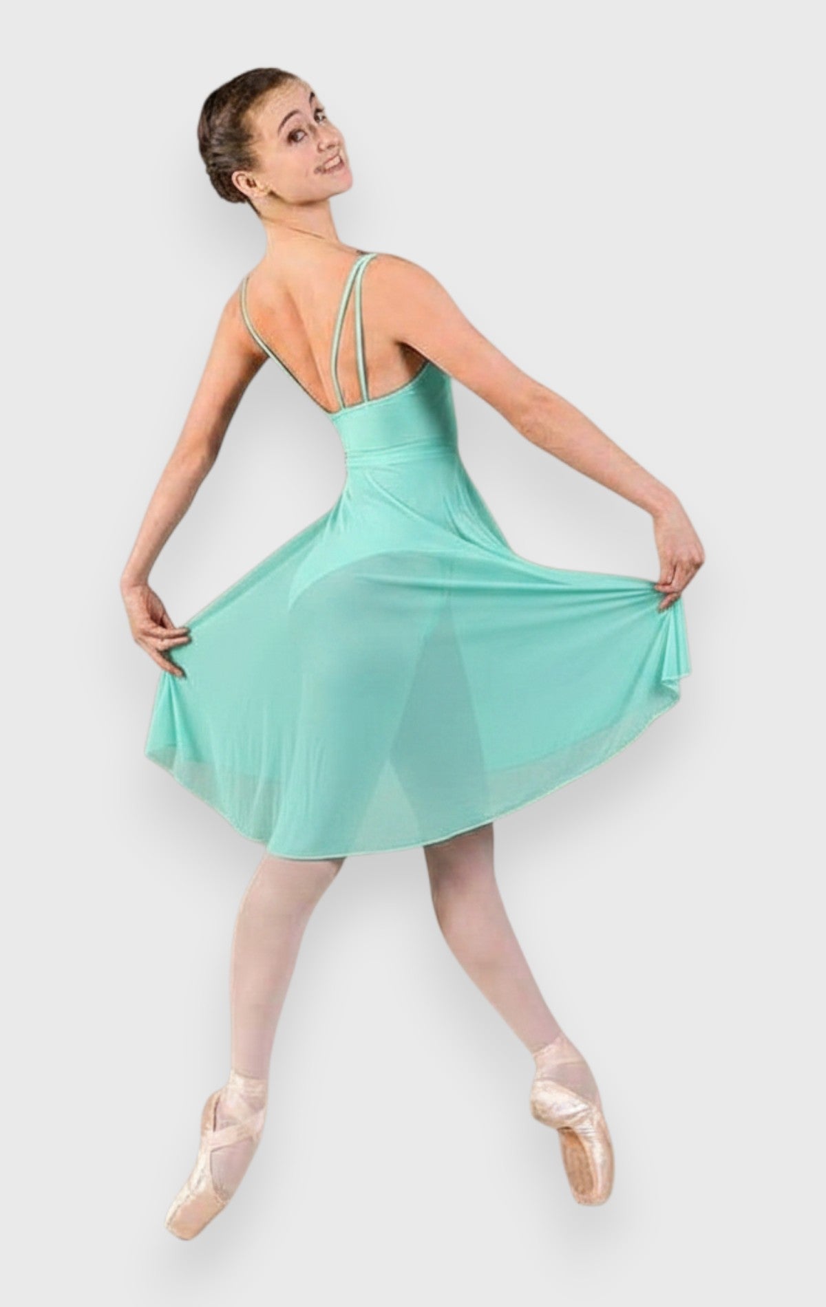 DanzaShop emerald green empire line ballet dress with thin adjustable straps and long tulle skirt worn by a dancer.